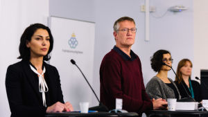 Den svenske statsepidemiologen Anders Tegnell har varit ett bekant inslag i nyheterna i år. Nu säger han att det småningom kan bli aktuellt för svenskar att få resa till Finland igen. Anders Tegnell och andra personer står framför talarpodier och mikrofoner under en presskonferens.