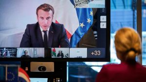Frankrikes president Emmanuel Macron anordnade den digitala givarkonferensen. En kvinna tittar på en man i en tv-skärm.