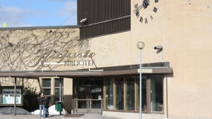Kyrkslätts bibliotek ska uppstå i ny skepnad om några år. en ljus tegelbyggnad. ovanför dörren finns texten kirjasto - bibliotek