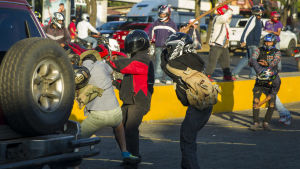 Unga män i motorcykelhjälmar anfaller en demonstrant under protesterna den 18 april i Managua. Unga män i motorcykelhjälmar anfaller en demonstrant under protesterna den 18 april i Managua.