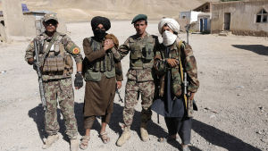Talibankrigare och afghanska soldater under ett kort eldupphör år 2018. Talibanrebeller med regeringssoldater i Kabul under ett eldupphör i somras