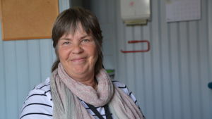 Christel Enholm har jobbat i Borgby skola i 25 år. Kvinna ler i ett lärarum med ljusblåa träväggar.
