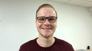 Det viktigaste som jultomte är att man kommer med julglädje och med glimten i ögat, säger Nyman. en kille i svarta glasögon och mörk jultröja ler mot kameran