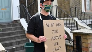 Det är många som demonstrerat utanför Cummings hem under de senaste dagarna. "Varför står du över lagen" står det på den här demonstrantens plakat. En demonstrant håller en skyld med texten varför står du över lagen