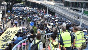 De talrika utländska journalisterna som bevakar Hongkong upplever att de är försatta i en svår situation. En del av dem förmodas lämna territoriet. Journalister står och tittar ut över mängder med människor med paraplyn