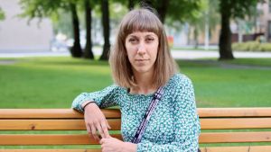 Kristina tänker att hon lever för två personer nu. Kristina Huhtasalo är klädd i en grön tröja och sitter på en parkbänk.