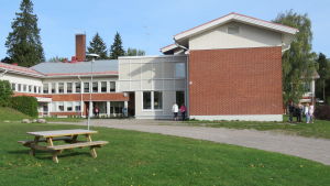 I Höjdens skola i Tenala får de äldsta skoleleverna gå ut på rast tillsammans, oberoende av vilken klass de går i. I de yngsta klasserna måste eleverna hålla sig till den egna klassen och i egna rastområden. En skolbyggnad i rött tegel. Höjdens skola i Tenala. Tidig höst, september.
