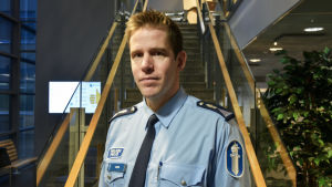Mikael Appel på polisinrättningen i Österbotten berättar att katalysatorstölderna blir allt flera. Man iklädd polisunform tittar in i kameran med neutralt ansikte. En aula med trappa i bakgrunden.