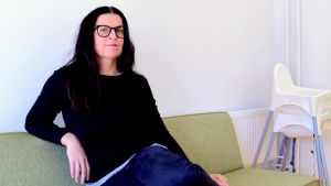 Micaela Röman. Arkivbild. Micaela Röman sitter på en grön soffa och ler till kameran