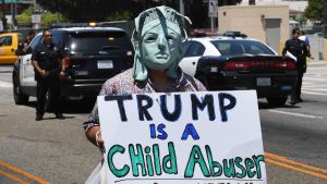 En demonstrant bar en skylt med texten "Trump är en barnmisshandlare" under en demonstration i Los Angeles den 30 juni. En demonstrant bar en skylt med texten "Trump är en barnmisshandlare" under en demonstration i Los Angeles den 30 juni.