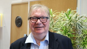 Raymond Wesander. En medelålders man med grått hår och glasögon står framför en växt.