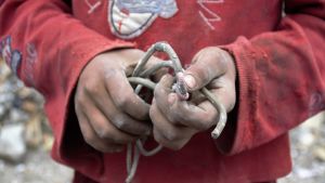 Gamla kablar är eftertraktade byten i ruinerna. Pojke håller en gammal kabel i sina händer