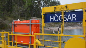 Färjturen mellan Nagu Storlandet och Högsar tar 4-6 minuter. Bild från Högsar färja där skylten Högsar syns och en räddningsflotte.