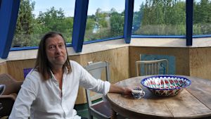 Jan-Erik Andersson högst upp i Bladhuset, i tornet som liknar en blåklocka. I bakgrunden skymtar Åbo slott. Jan-Erik Andersson sitter i torndelen i sitt Bladhus. Genom fönstren skymtar Åbo slott.