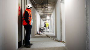 Byggarbetare står i en korridor. 