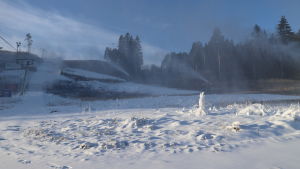 Så här såg det ut när backen fylldes med snö i januari 2020. Vintern 2020 var snöfri ända till februari. Vid Hirvensalo skidbacke i Åbo skjuter snökanoner snö en solig vinterdag.