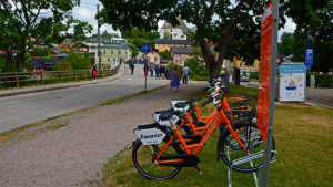 I år kommer antalet stadscyklar att öka från 60 till 100 stycken. Orangefärgade cyklar står i en cykelställning.