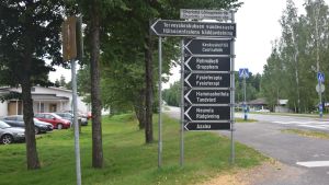 Det blir förändringar inom social- och hälsovården när Sjundeå bygger nytt. Svart skylt utanför hälsocentral vid väg. Gräsmatta på andra sidan. Parkeringsplats i bakgrunden.