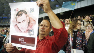 En ukrainsk man håller under fotbolls-VM i Ryssland upp en bild på den fängslade ukrainska filmregissören Oleg Sentsov. Demonstration till förmån för den fängslade ungerska filmaren Oleg Sentsov