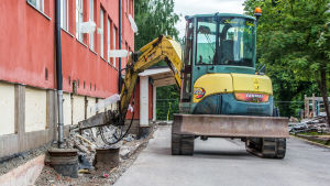 Renoveringen av Kvarnbackens skola har dragit ut på tiden. Grävmaskin gräver utanför skolhus