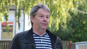 Juhani Holm (SDP) har inte ännu bestämt sig för hur han röstar. En man med kort grått hår står på en gård.