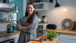 Ruokakirjailija- ja stylisti Elina Ylitervo katsoo keittiön tason äärestä hymyillen kameraa kohti.
