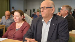 - Aldrig har vi haft pengar, men ändå har vi byggt hela tiden och det är jag glad över att vi har gjort, säger Kalevi Kallonen som varit politiskt aktiv i kommunen i 30 år. Man med glasögon sitter i en bänk med en kvinna bredvid sig.