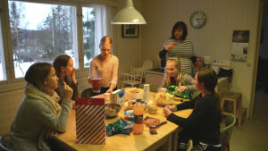 Knytkalas. Från vänster till höger Mariska Nykänen, Madicken Lund, Lina Nygård, Elin Jordas och Sofia Lill-Smeds. I bakgrunden ungdomsledare Samira Al-Far. Flera flickor sitter runt ett bord med godsaker. I bakgrunden står en kvinna.
