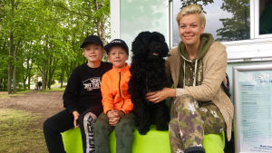 Från vänster: Leonard Korander, Vincent Korander, Vilda och Daniela Fogelholm. Kunder med hund utanför glasskiosk.