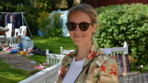 Sofie Roschier tycker Lovisa är en härlig stad. Kvinna i solglasögon står och ler på en innergård.
