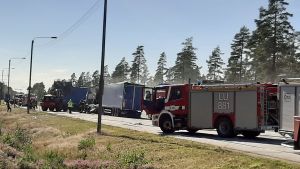 Ingen skadades i olyckan men vägen var avstängd i fem timmar. Brandkår och annan räddningspersonal hjälper till på en väg där en långtradare fattat eld.