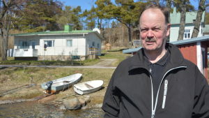 Jan Backman vid sina båtar i Kapellhamnen. Porträttbild på Jan Backman i Kapellhamnen i Hangö.