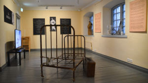 Sebastian Derkert har arbetat med installationen på nedre våningen. installation, i mitten en rostig järnsäng och affischer på väggarna