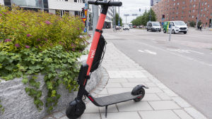 Elsparkcyklarna parkeras ofta på trottoaren och då kan det vara svårt för synskadade att ta sig fram. en röd elsparkcykel.