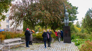Fågelstatyn, rest till minne av Jarl Hemmer, var ett av stoppen på vandringen. En grupp personer tittar på en staty i en stadspark.