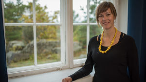 Elisabeth Nybacka, modersmålslärare trivs med att se sina elever bli vuxna. kvinna med halsband står vid fönster