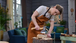 Den svenska yxmakaren Julia Kalthoff hugger till ett yxskaft med en täljyxa.
