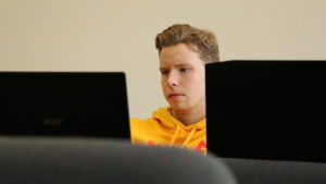 Matias Zilliacus tillhörde den grupp som fick pris för bästa koncept. En pojke med gul munktröja sitter framför en dator.