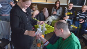 Vernissagen avslutades med blomutdelning. Person får blomma i samband med en vernissage.