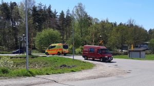 Här vid järnvägskorsningen i centrum av Ekenäs kör bilar, tåg och större fordon. Två bilar kör över en järnvägskorsning i Ekenäs.