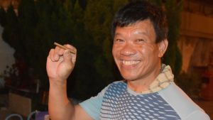 När Chen Kong-wah firar avslutar han gärna sin kväll med en cigarill. Det är en vana som han ämnar hålla fast vid. Leende kinesisk man med en cigarill mellan fingrarna.
