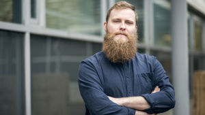 Jonas Forsbacka fick Språkblomman för att han bryr sig om sitt språk. Porträttbild av Jonas Forsbacka, som står med armarna i kors.
