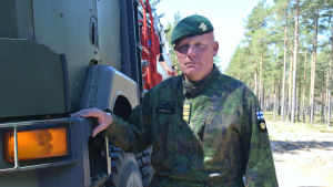 Kommendör Jörgen Engroos ansvarar för övningen. En bild på en man i militärkläder. Han har en grön barett och står lutad mot en lastbil.