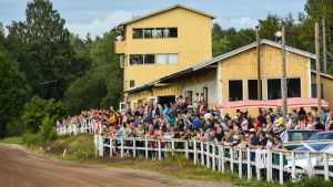 Det finns 43 travbanor i Finland, över hälften av dem är sommartravbanor. Lovisa travbana är en av dem som blomstrar upp på sommaren. Mycket publik längs med travbanan. Den gula träbyggnaden syns.