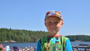 Albin Niemi har hoppat från bryggan och lekt kull på stranden. Liten pojke i närbild.