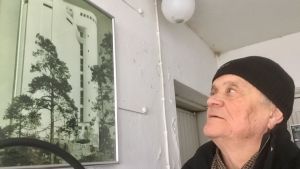 Tom Törnroos bredvid ett gammalt fotografi av Karis vattentorn. Man tittar på fotografi av vattentorn i vattentornet.