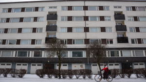 I Vasa är det större efterfrågan på höghustomter än småhustomter. Person cyklar framför höghus en vinterdag i Vasa.