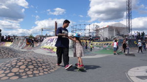 Elvira Mäkelä får hjälp med balansen på skejtboarden av pappa Wilson Mäkelä. Pappa som drar sin fem-åriga dotter på en skejtboard i Söderviks skejtpark