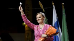 Först på femte plats har vi Centern som efter valet av Katri Kulmuni till ordförande verkar ha fått aningen bättre fart. Centern har i denna undersökning ett stöd på 12,8 procent. Katri Kulmuni svingar ordförandeklubbar i Kouvola. Hon står på scen med blommor under ena armen och ordförandeklubban höjd i den andra.