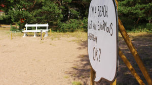 På Bellevuestranden finns förutom bänken också en stor pratbubbla som påminner om att stranden inte är en askkopp. en stor skylt påminner om att stranden inte är en askkopp